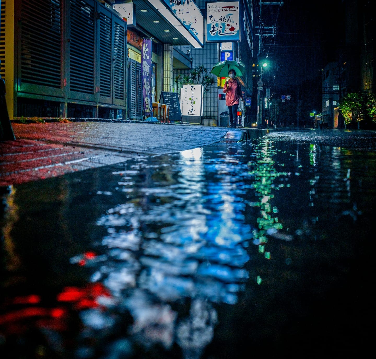 Neon reflections on a wet street at night