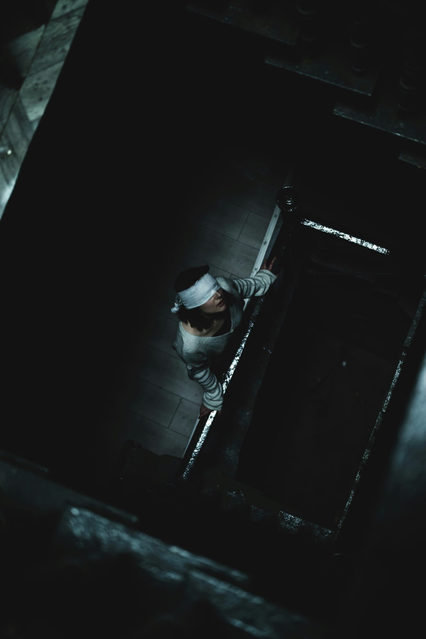 A figure seen through a dark doorway from above