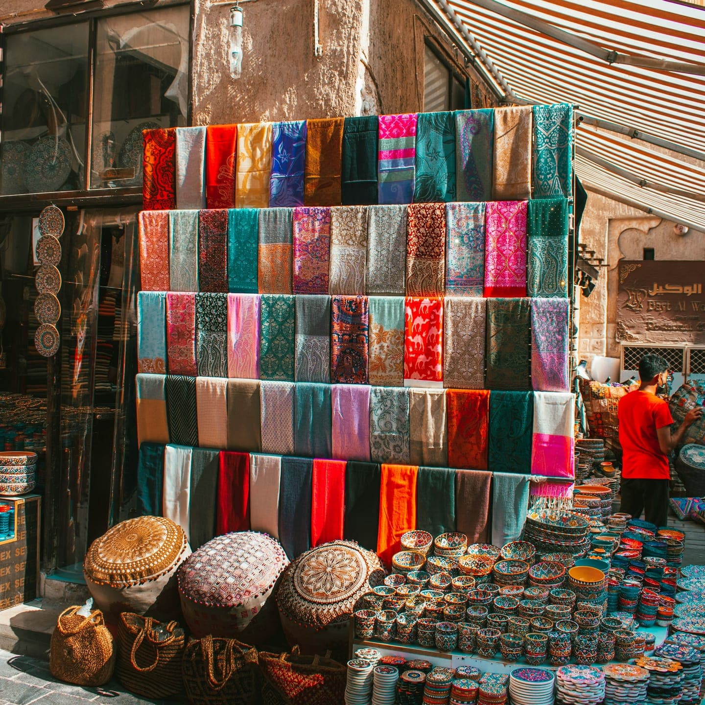 Stacks of colourful scarves and baskets at a market stall