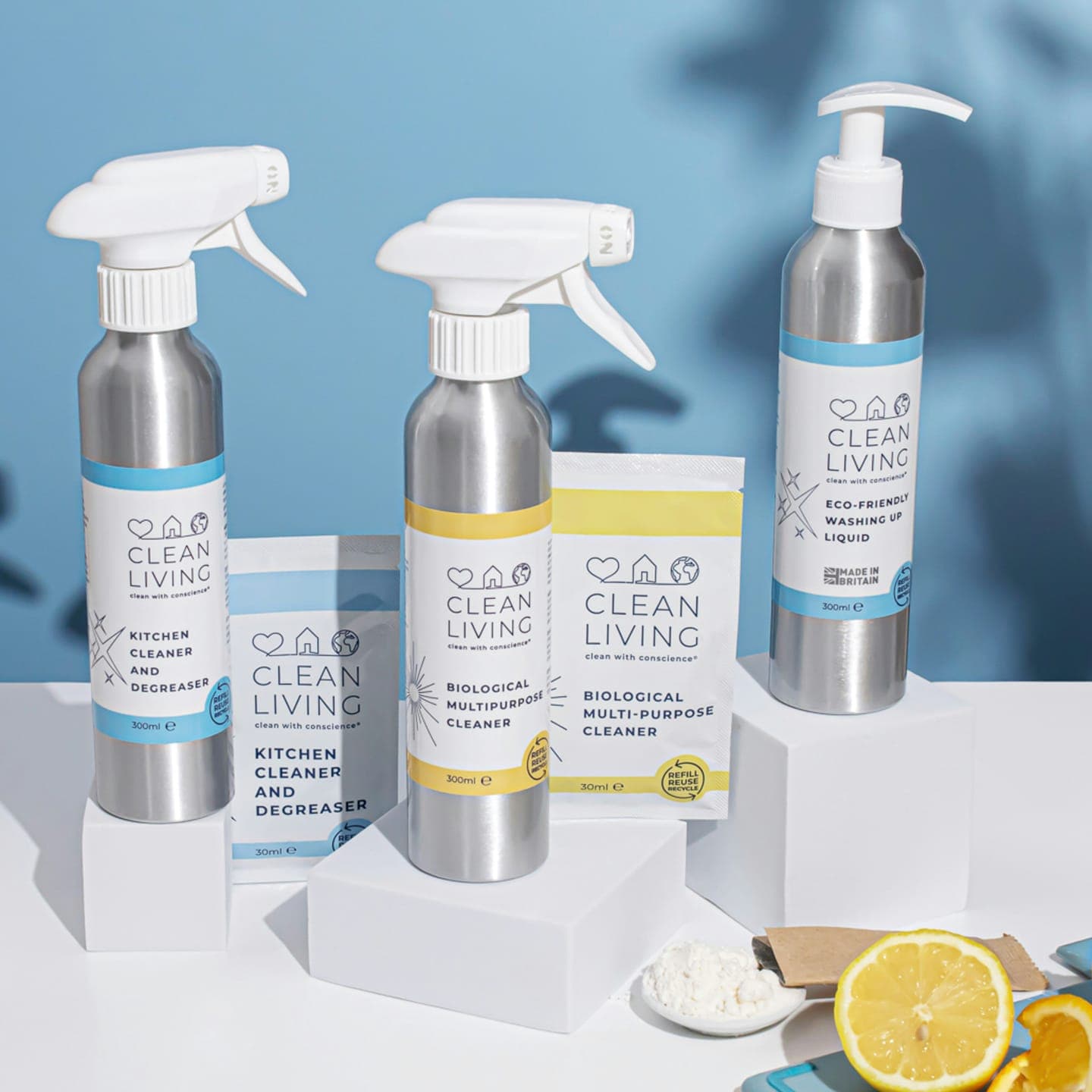 Spray bottles of cleaning products on white blocks with lemons
