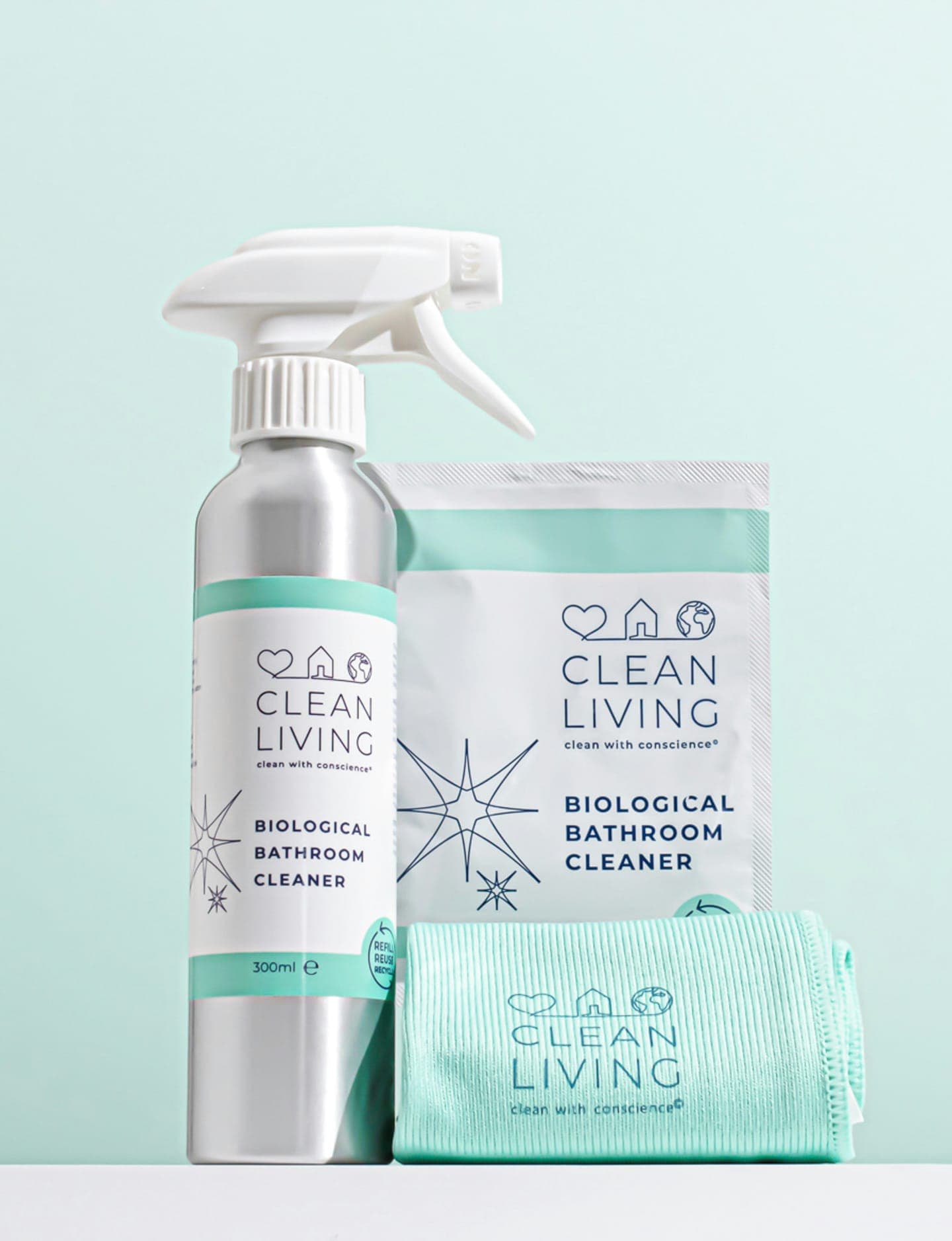 A spray bottle, a refill pouch and a cloth on a pale blue background