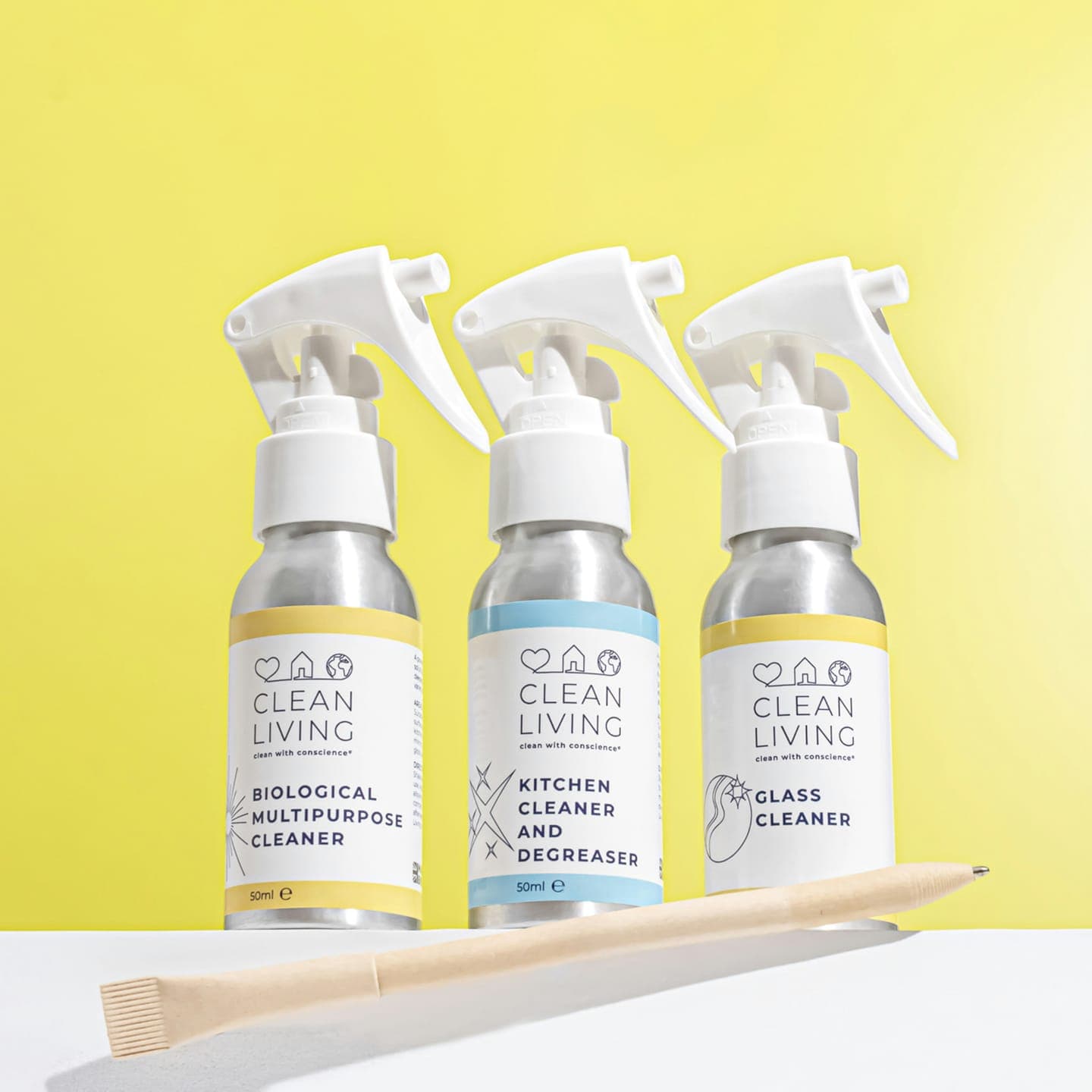 Three spray bottles in front of a yellow wall