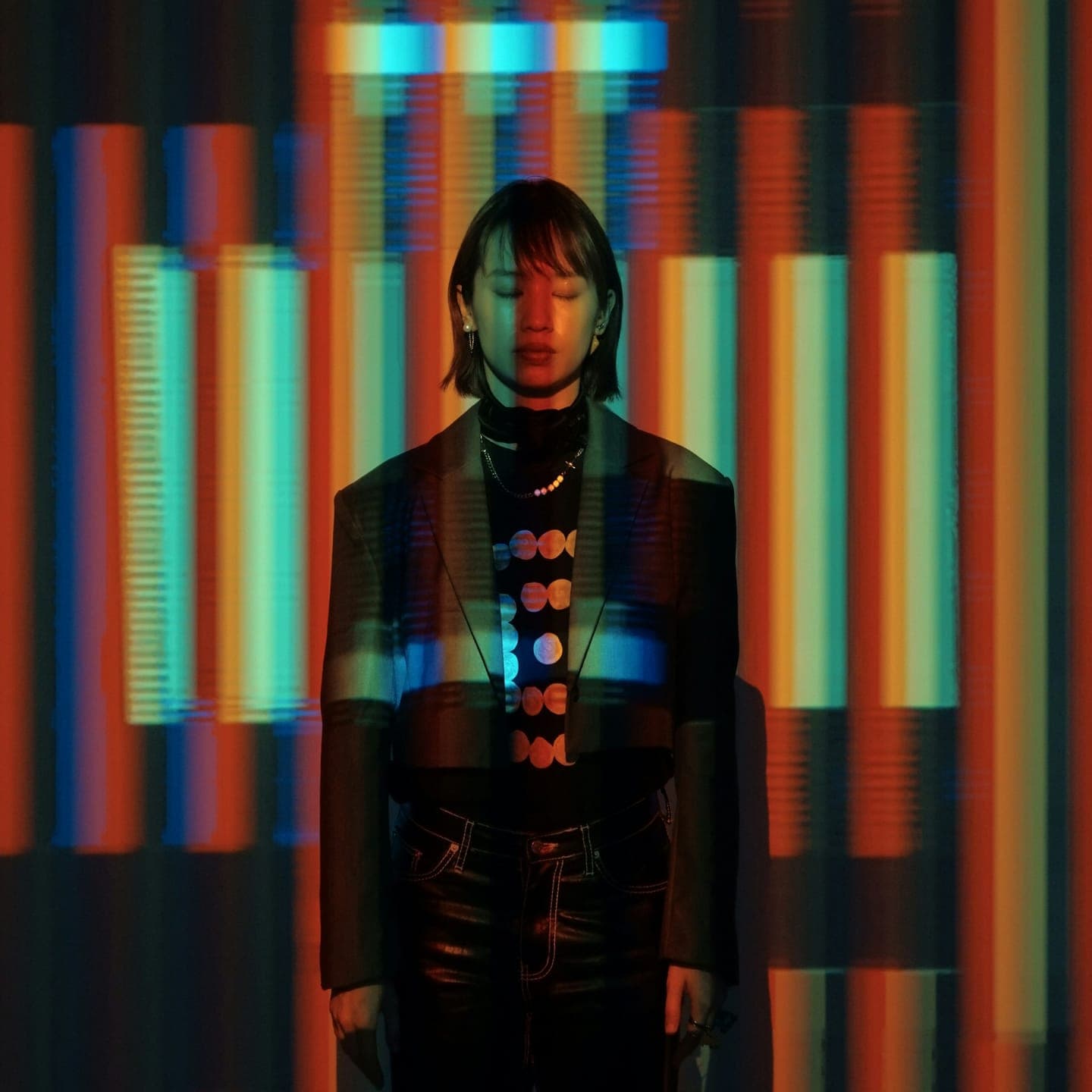 A woman standing in stripes of red and blue light