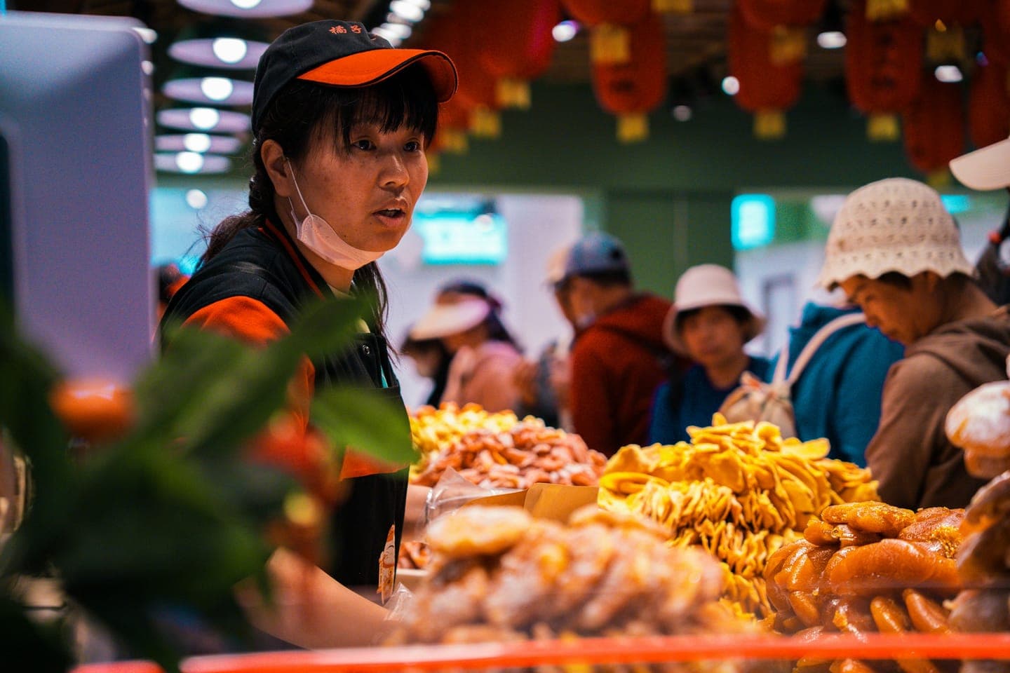 A vendor in a cap behind a counter of fried food