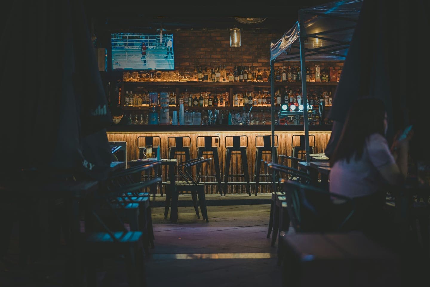 A dim bar with stools and warm lights