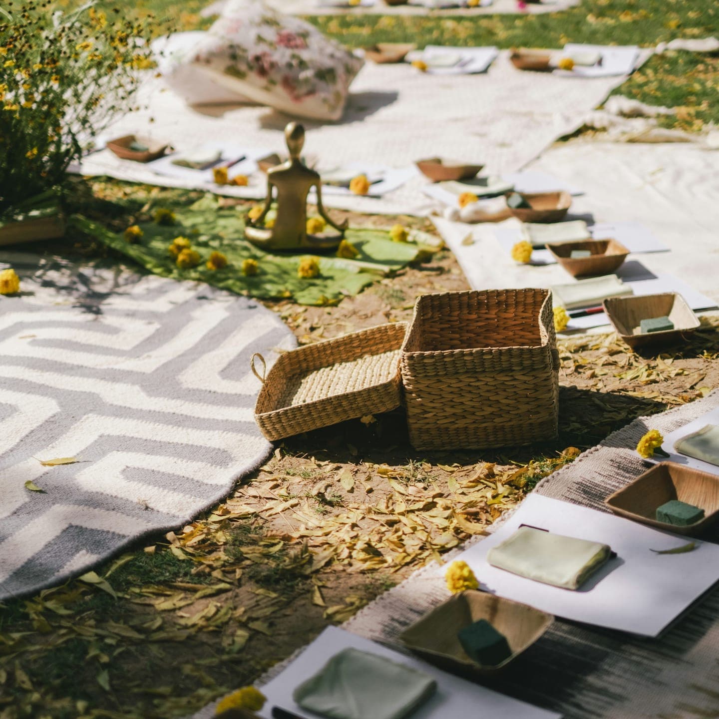 Rugs, baskets and small bowls laid out on the grass