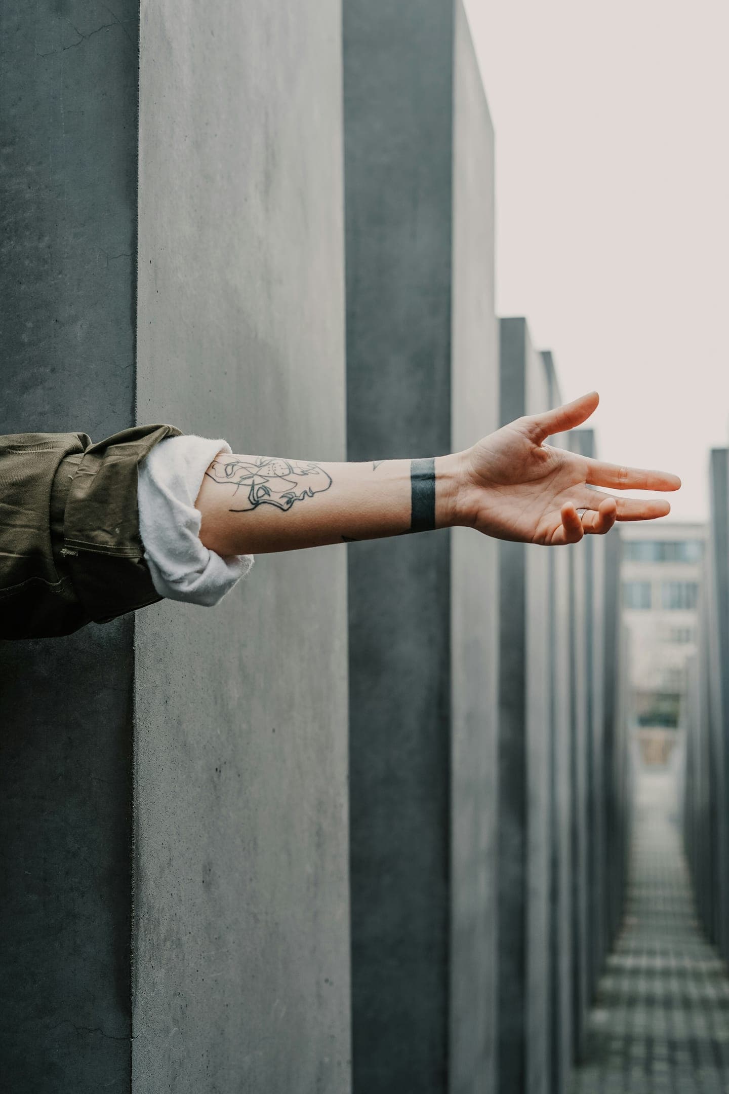 An arm reaching out between concrete pillars