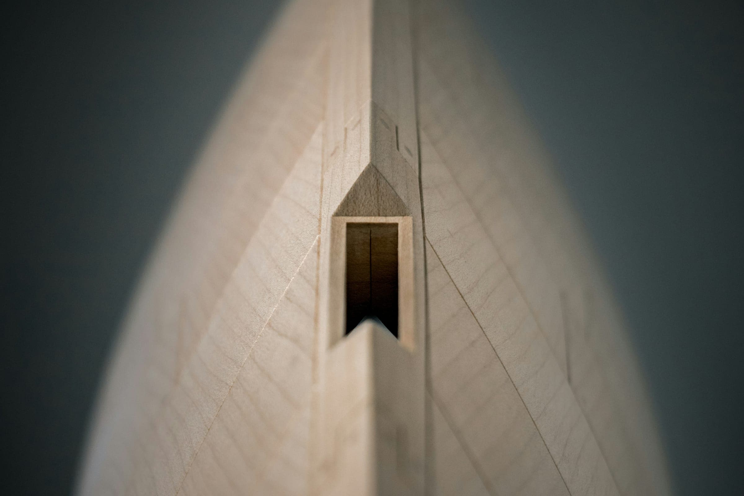 The pale wooden bow of a boat narrowing to a dark opening